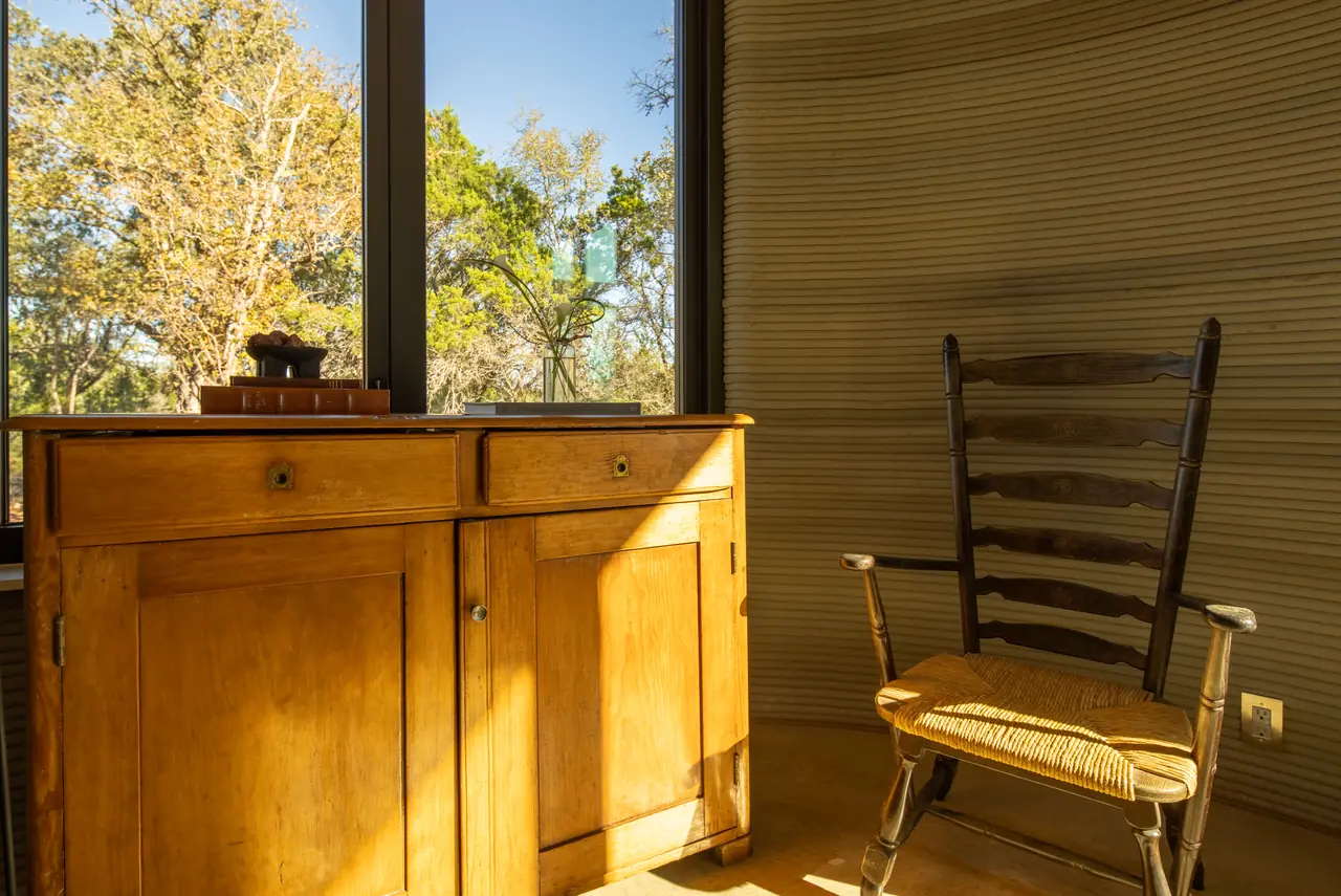 Antique dresser and rocking chair by a tall window