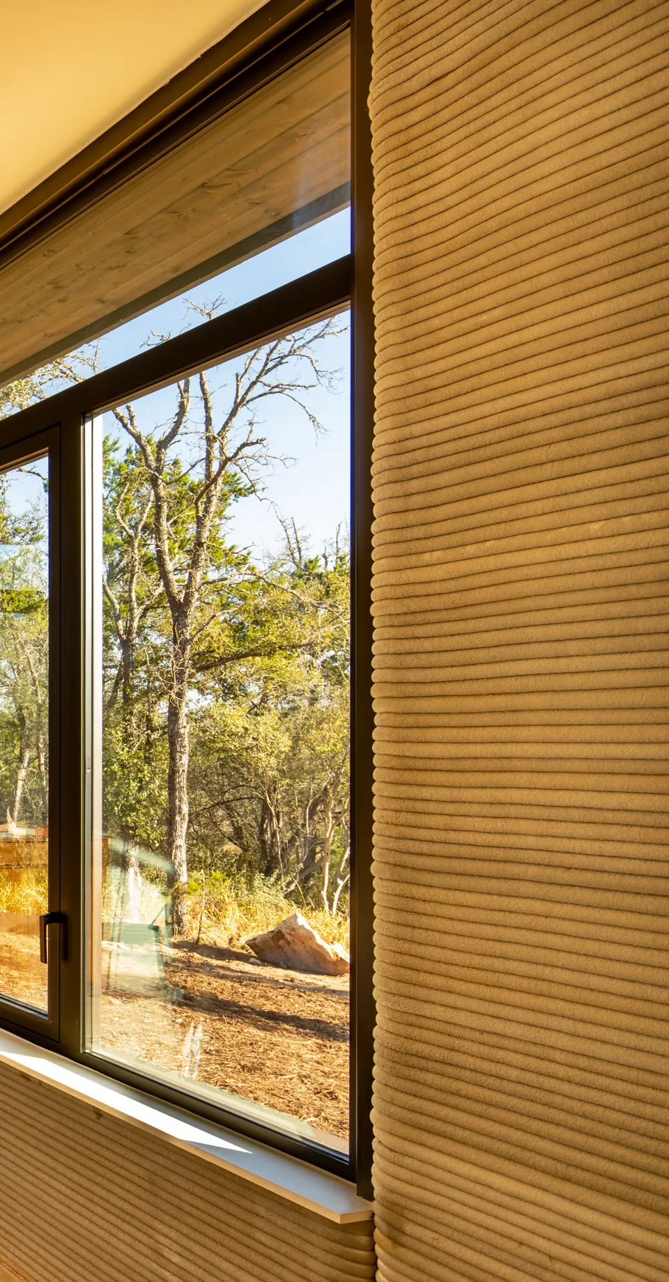Printed concrete layers beside a tall window