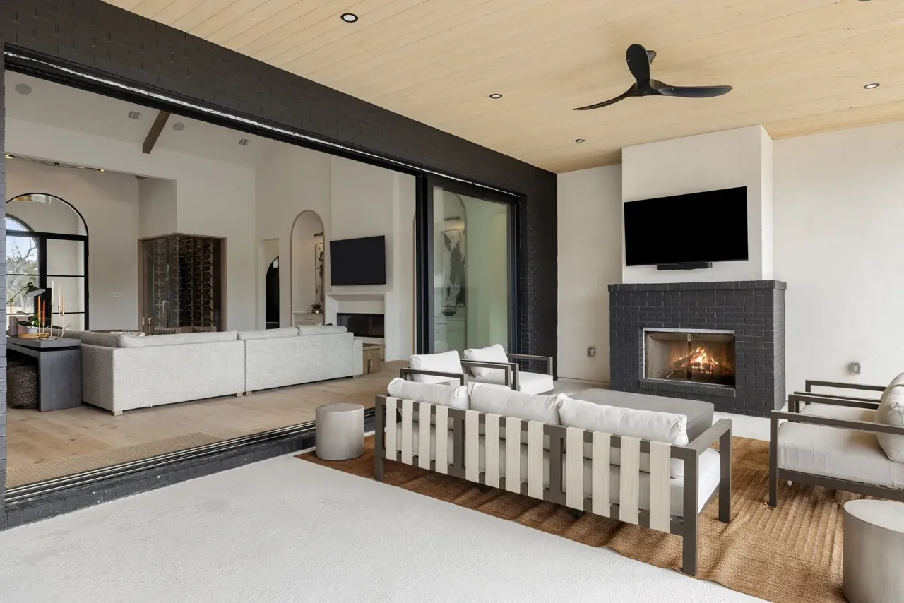 Covered terrace with a fireplace and TV