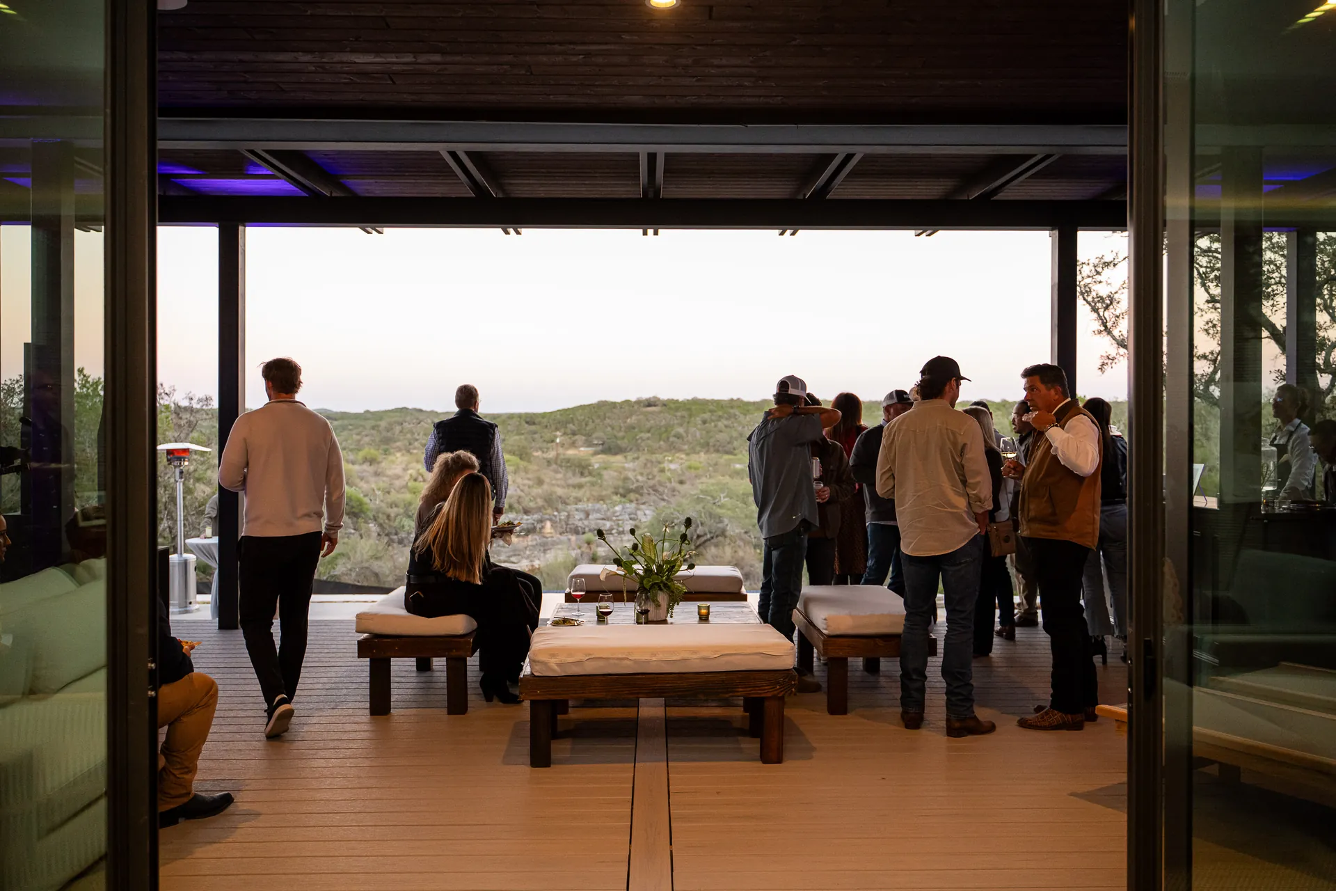 Guests on Aura's covered deck at dusk, looking over the canyon