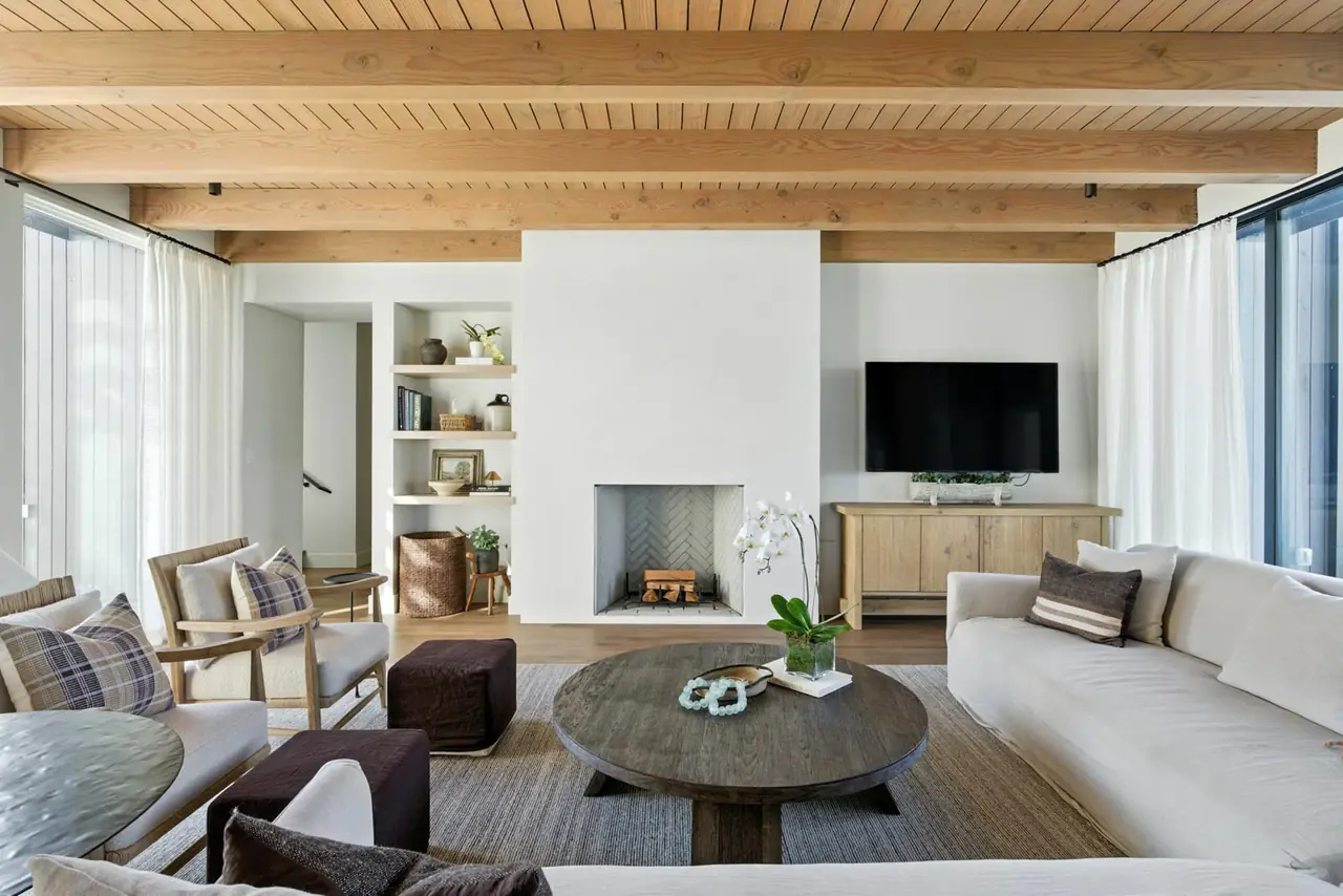 Living room with a beamed wood ceiling and a plaster fireplace